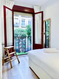 a bedroom with a bed and a large window at Puerta de Toledo VII - Apartamento de 2 dormitorios con Balcón in Madrid