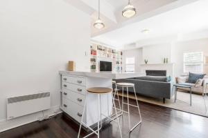 Il comprend une cuisine et un salon avec un bar et un canapé. dans l'établissement 'The Chatsworth' Chic Urban Living near High St, à Melbourne