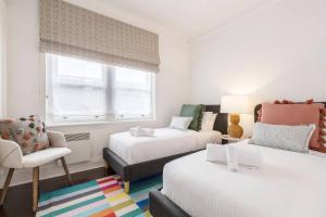 une chambre avec deux lits et une chaise et une fenêtre dans l'établissement 'The Chatsworth' Chic Urban Living near High St, à Melbourne