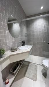 a bathroom with a sink and a mirror and a toilet at Flat Charmoso Mercure - By Palm Rooms - 289 in São Paulo