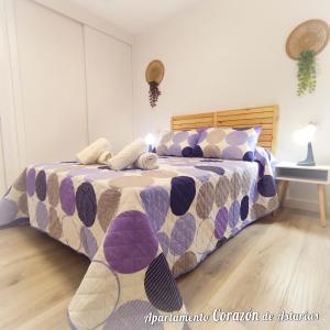 a bedroom with a bed with a purple at CORAZÓN DE ASTURIAS in Piedras Blancas