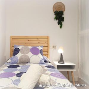 a bedroom with a bed with a wooden headboard at CORAZÓN DE ASTURIAS in Piedras Blancas