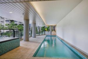 an indoor swimming pool in a building with a building at 'Riverfront Flow' Poolside and Portside in Hamilton in Brisbane