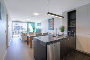 a kitchen with a counter and a dining room at Fall in Love with Waterfront Resort-style Living in Brisbane