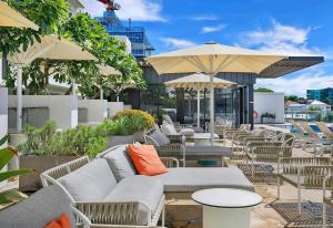 a row of chairs and tables with umbrellas on a patio at 'Brightly Boutique' A CBD Resort-style Escape in Brisbane