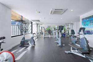 a gym with several treadmills and cardio machines at 'Brightly Boutique' A CBD Resort-style Escape in Brisbane