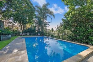 a swimming pool in a yard with trees at 'Riverside Terrace' Inner-city Retro-chic with Pool in Brisbane