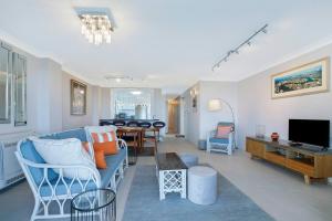 a living room with a blue couch and a television at 'Riverside Terrace' Inner-city Retro-chic with Pool in Brisbane