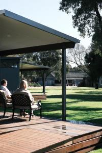 two people sitting on a bench under a pavilion at Buller Wines in Rutherglen