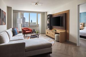 a living room with a couch and a bed and a television at Washington Marriott at Metro Center in Washington