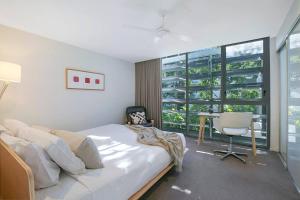 a bedroom with a bed and a desk and a window at The Sun Catcher - A Trendy South Brisbane Townhouse in Brisbane +29 photos