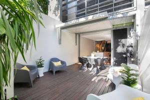 een patio met een tafel en stoelen en een gebouw bij The Sun Catcher - A Trendy South Brisbane Terrace in Brisbane