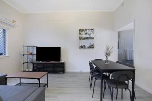 ブリスベンにあるCity Centre Comfort - Your Home in Vibrant Brisbaneのリビングルーム(テーブル、テレビ付)