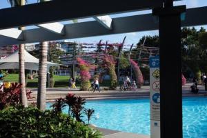 a swimming pool with people walking around a park at The Sun Catcher - A Trendy South Brisbane Townhouse in Brisbane