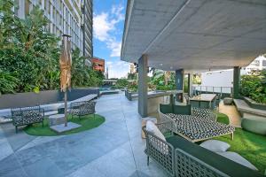 un patio avec des chaises et des tables dans un bâtiment dans l'établissement The Skyring - Effortless Resort-style Living, à Brisbane
