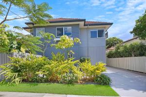 uma casa com uma cerca em frente a um quintal em Nundah's Lush Haven - Serene Family Townhouse Escape em Brisbane