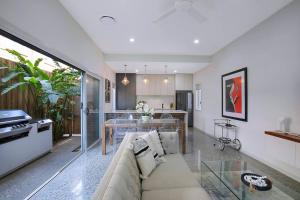 een woonkamer met een bank en een tafel bij Nundah's Lush Haven - Serene Family Townhouse Escape in Brisbane