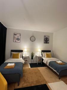 1 dormitorio con 2 camas y 2 mesas con lámparas en Noah Longstay Borås en Borås
