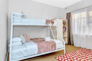 een slaapkamer met 2 stapelbedden in een kamer bij Adventure Awaits - Footsteps from West Beach in Henley Beach South