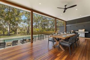 una gran terraza con mesa y sillas. en Thalassa Huskisson by Experience Jervis Bay en Huskisson