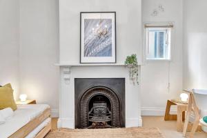 ein Wohnzimmer mit einem Kamin mit einem Bild an der Wand in der Unterkunft The Lemon Tree - Charming Cottage in North Adelaide in Adelaide