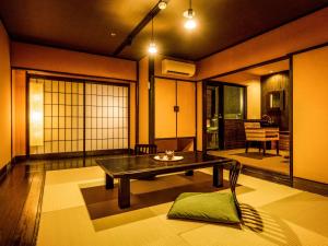 a japanese room with a table and a chair at Yukai Resort Premium Miyoshiya in Shinonsen