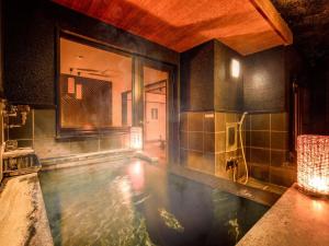 a room with a pool of water in a bathroom at Yukai Resort Premium Miyoshiya in Shinonsen