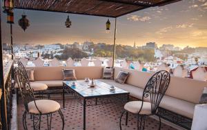 a balcony with tables and chairs and a view of the city at Tangier Kasbah Hostel in Tangier