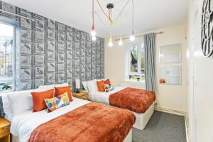 a bedroom with two beds and a wall with a mural at 3 Bedroom Flat Near Finsbury Park, Manor House Station in London