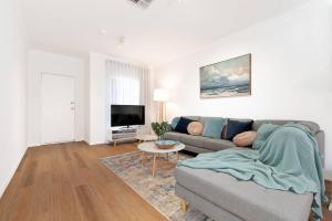 a living room with a couch and a tv at Colley's Nest - Family-friendly Townhouse with Patio in Adelaide