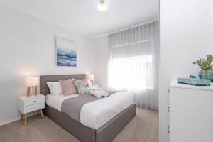 ein Schlafzimmer mit einem Bett und einem Fenster in der Unterkunft Colley's Nest - Family-friendly Townhouse with Patio in Adelaide