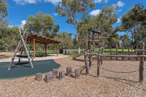 a playground in a park with a swing at Colley's Nest - Family-friendly Townhouse with Patio in Adelaide