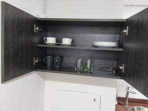 una cocina con armarios, platos y vasos en blanco y negro en Apartahotel, en Caracas