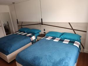 Dos camas en una habitación con almohadas azules. en Apartahotel, en Caracas 2 fotos más