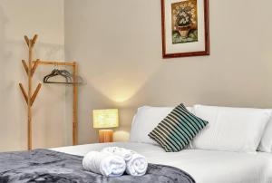 ein Schlafzimmer mit einem Bett mit Handtüchern darauf in der Unterkunft East Parklands Cottage - A Dreamy Garden Hideaway in Rose Park