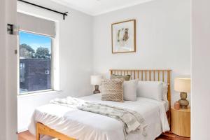 um quarto branco com uma cama e uma janela em City Life meets Urban Style at Kent Town Gem em Rose Park