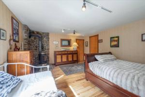 a bedroom with two beds and a stone fireplace at Cozy Home with Lake Views Decks Hot-Tub Walk to Private HOA Beach in 5 min in Tahoe City