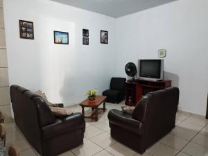 a living room with two chairs and a tv at Rancho Imperador in Pôrto Primavera