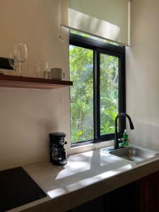 a kitchen counter with a sink and a window at Arena Tuane in Tulum