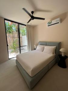 a bedroom with a bed with a ceiling fan at Arena Tuane in Tulum