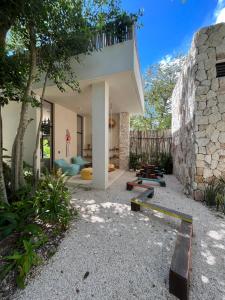 a house with a stone wall and a patio at Arena Tuane in Tulum
