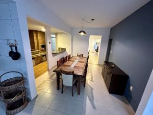 a kitchen and dining room with a wooden table and chairs at Casa Mariscal perto do mar in Bombinhas