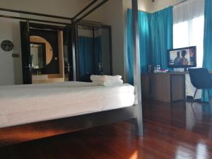 a bedroom with a bed with blue curtains and a mirror at Avani Sepang Goldcoast Resort Family Villa in Bagan Lalang
