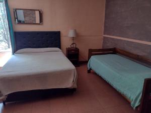 Habitación de hotel con 2 camas y ventana en Cabañas Nueve Lunas en Santa Rosa de Calamuchita
