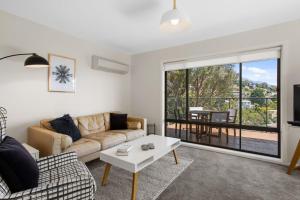 ein Wohnzimmer mit einem Sofa und einem Tisch in der Unterkunft The View 2 bed unit with stunning Hobart outlook in Hobart