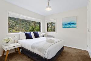 a white bedroom with a large bed and two windows at The View 2 bed unit with stunning Hobart outlook in Hobart