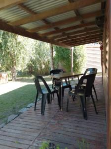 una terraza de madera con mesa y sillas. en Las Cabañitas en Necochea