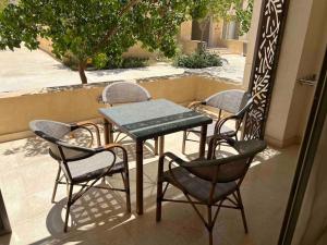 einen Tisch und Stühle auf einer Veranda mit einem Tisch und Stühlen in der Unterkunft One Bedroom - Mangroovy El Gouna in Hurghada