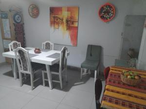 uma sala de jantar com uma mesa branca e cadeiras em CASA HOSTEL 129-A em Cajamarca
