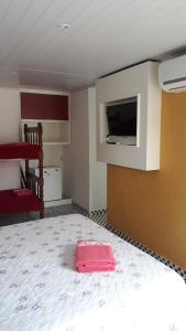 a room with a bed and a flat screen tv at Hospedaria Gaúcha in Penha
